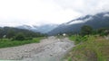 The small river with the background of the mountain covered with cloud