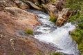 Small river and cascade between the rocks and the arid vegetation Royalty Free Stock Photo