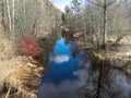 A small river in early spring, blue skies and reflections in the water Royalty Free Stock Photo