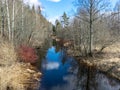 A small river in early spring, blue skies and reflections in the water Royalty Free Stock Photo