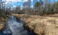 A small river in early spring, blue skies and reflections in the water Royalty Free Stock Photo