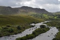 Small River Flow in Green Vegetation and Mountain Landscape in a National Road in Ireland Royalty Free Stock Photo