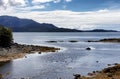 Small river flowing into Alaska lake during early autumn with sun sparkles on the water