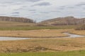 A small river flowing through meadows and agricultural fields. spring. Cloudy sky. Selective focus Royalty Free Stock Photo