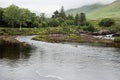 Small river flows into ocean, Mountains in the background. Connemara, Ireland. Nature background. Green trees and fields Royalty Free Stock Photo