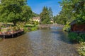 Small river with a pedestrian bridge in a green park with blue s Royalty Free Stock Photo