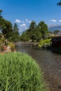 Small river with pedestrian bridge in a green park with blue sky Royalty Free Stock Photo