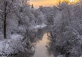 Small river running through the white snowy forest in sunset Royalty Free Stock Photo