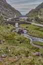 Small road winding through the gap of dunloe, Ireland. Panoramic view of the Gap of Dunloe, Ireland. Small stream flowing through