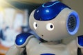 A small robot with a human face and a humanoid body. Artificial intelligence - AI. Blue-and-white robot.