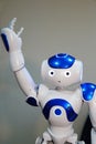 A small robot with a human face and a humanoid body. Artificial intelligence - AI. Blue-and-white robot.