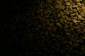 Small rock bed with yellow light gradient and black shadow as empty negative space Royalty Free Stock Photo