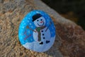 Small rock painted light blue and white with snowman and Let it Snow Royalty Free Stock Photo