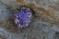 Small rock painted white and purple swirls with purple heart