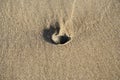 A small rock submerged into a dry sand after a low tide