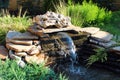 Small rockery with waterfall in a garden Royalty Free Stock Photo