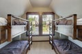 Small room with vaulted ceiling above garage with four bunk beds for kids Royalty Free Stock Photo