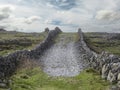 Small rough stone road up hill and fences and view on stunning landscape of Aran island, county Galway, Ireland. Popular travel Royalty Free Stock Photo