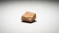 A small roughly cuboidal piece of sandstone rests on a smooth white Royalty Free Stock Photo