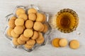 Small biscuits in plate in shape star, transparent cup with tea, cookies on wooden table. Top view Royalty Free Stock Photo