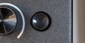 Small round blank empty black button next to metallic knob on textured electronic device surface, template, top view, from above, Royalty Free Stock Photo