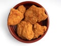 A round bowl of crispy fried chicken nuggets on a white background Royalty Free Stock Photo