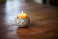 small round candle holder with a burning tealight