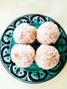 Small round doughnuts with coconut on plate Royalty Free Stock Photo