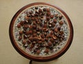 On a small round table there is a drawing of dried chestnut fruits Royalty Free Stock Photo