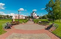 A small rounded garden with comfortable wooden benches against the background of the church church in the distance Royalty Free Stock Photo