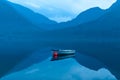 small rowing boat reflects in the water