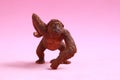 Small rubber ape toy isolated on a pink background