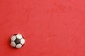 Small rubber football toy on a red surface