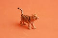 Small rubber tiger toy isolated on an orange background