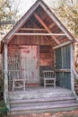 Small Rustic House with Wooden Chairs on Porch Royalty Free Stock Photo