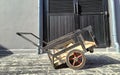 Small rusty old black cargo cart. midday sunlight