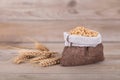 A small sack full of wheat and a few scattered ears of wheat Royalty Free Stock Photo