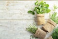 Small sacks with fresh herbs on wooden background