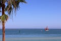 A small sailboat in a bay with a green buoy