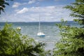 Small sailboat floating in the lake framed by trees