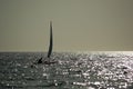 Small sailboat sailing on calm sea at sunset