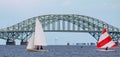 Small sailboats sailing in the bay in front of brige leading to Fire Island in Babylon