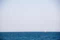 Small sailing yacht with big white sails in the open sea on the horizon Royalty Free Stock Photo