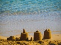 Small sand castles near water on a small beach in Greece Royalty Free Stock Photo