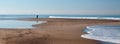 Person on small sandbar where the Pacific ocean and the Santa Clara river meet at Surfers Knoll beach in Ventura California USA