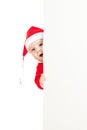 Small Santa child looking from behind placard