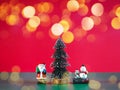 Small Santa Claus, snowman and pine tree on green color over red background with golden bokeh Royalty Free Stock Photo