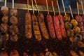 Small sausages and meat balls on a stick in a spicy sauce