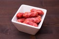 Small sausages on a square bowl on wood