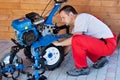 Small scale agriculture - man checking on small motorized tiller Royalty Free Stock Photo